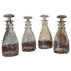 three glass decanters are lined up on a white background, one is empty