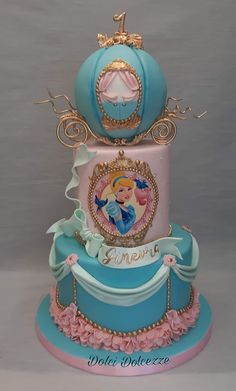 a three tiered cake with an image of princess on the top, and blue frosting