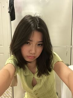 a young woman sitting on top of a toilet in front of a sink with her hands behind her head