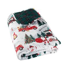 a quilted blanket with cars and christmas trees on it, sitting on top of a white surface