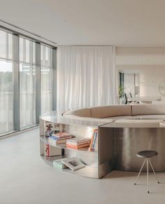 a living room filled with furniture and lots of windows next to a white floor covered in curtains