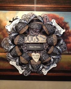 a dog's paw wreath is displayed in front of a painting on the wall