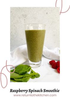 raspberry spinach smoothie in a glass with strawberries on the side