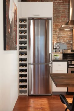 a stainless steel refrigerator and wine rack in a kitchen