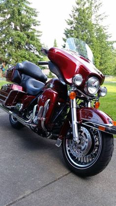 a red motorcycle is parked in the driveway