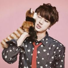 a young man is holding a stuffed animal