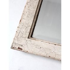 an old window frame with peeling paint on the outside and glass in the top half