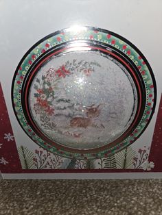 a glass plate sitting on top of a table next to a red and white box