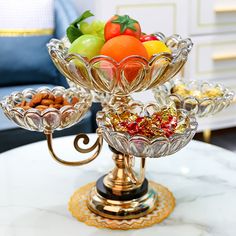 the fruit and nuts are on top of the glass bowl that sits on the table