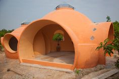 an orange building with a potted plant in it