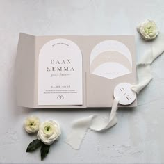 the wedding stationery is laid out with flowers