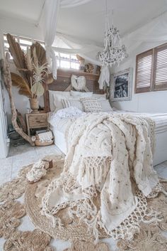 a bedroom with a bed covered in blankets and rugs on top of the floor