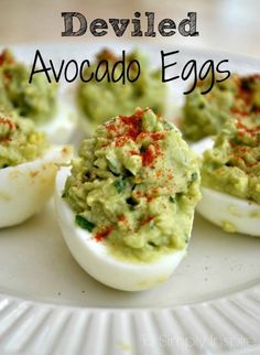 deviled eggs with guacamole in them on a white plate and the words deviled avocado eggs