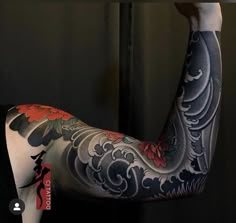 a man with tattoos on his arm and shoulder is doing a hand stand in front of him