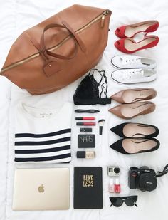 the contents of a woman's purse laid out on top of a white sheet