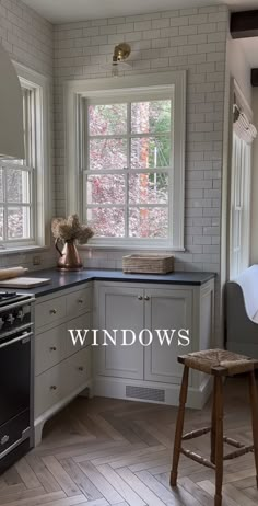 an image of a kitchen setting with white cabinets and black counter tops that has the words windows above it