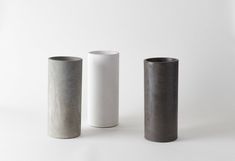 three different types of concrete vases on a white background