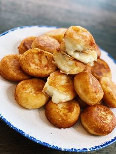 a white plate topped with fried food on top of a wooden table