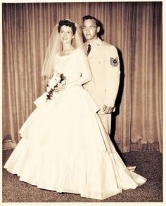 an old photo of a bride and groom posing for the camera in front of curtains