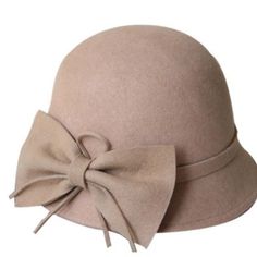 a beige hat with a large bow on it