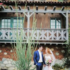 a bride and groom standing in front of a building