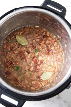 a pot filled with beans and meat on top of a stove