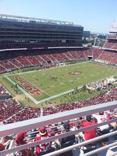 a football stadium filled with lots of red and white people sitting on the bleachers