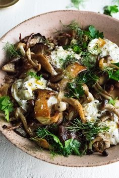 a bowl filled with mushrooms and feta cheese on top of a white tablecloth