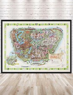 a framed map of disneyland world on a brick wall in a room with hardwood floors