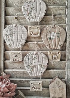 three hot air balloons are hanging on a wall with some flowers in the vase next to it