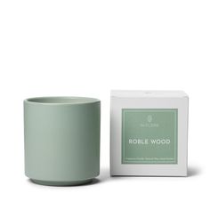 a candle that is next to a box on a white background with the words role wood in it