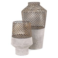 two gray vases sitting next to each other on a white surface with holes in them