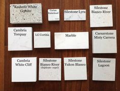 marble name tags are laid out on a wooden table with white and black labels in them