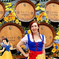 a woman standing in front of barrels with flowers on them