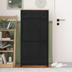 a black cabinet sitting in the middle of a living room next to a book shelf