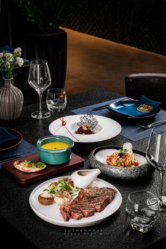 a table topped with plates and glasses filled with different types of food on top of it