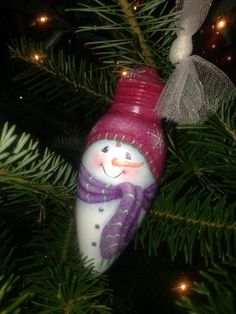 a snowman ornament hanging from a christmas tree