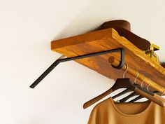 a wooden coat rack with clothes hanging from it