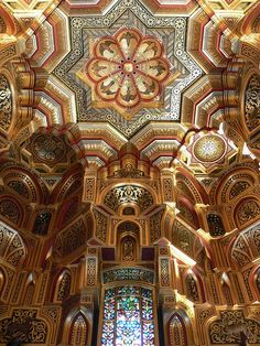 the interior of an ornate building with stained glass windows and intricate designs on the ceiling