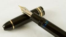 two fountain pens sitting on top of each other