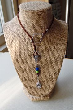 This brown faux suede lariat can be draped for a lower-sitting necklace--or double-wrapped for a shorter, choker-like look. Ornamented with a hand-beaded dangle made with Czech glass beads, as well as a silvertone peacock charm, this unique Peacock Feather Lariat completes any boho, southwest or casual look with simplicity and flair. Wire-wrapped by hand! You may also like our Peacock Beaded Necklace: https://www.etsy.com/listing/725488341/peacock-beaded-necklace-with-charm-and And our Peacock Feather Bracelet: https://www.etsy.com/listing/730270333/peacock-feather-bracelet-with-brown Peacock Feather Bracelet, Feather Bracelet, Tarot Bags, Feather Necklace, Feather Necklaces, Peacock Feather, Vintage Button, Lariat Necklace, Look Plus