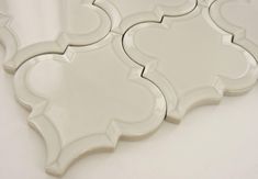 three white decorative tiles on a white surface