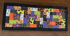 a patchwork quilt hanging on the wall in front of a door way with pumpkins and spider webs all over it