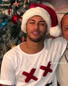 two men in santa hats are smiling for the camera