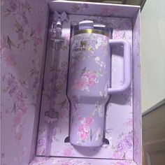 a purple coffee mug in a pink floral box with the lid open and handle extended