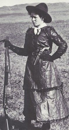 an old photo of a woman standing in a field