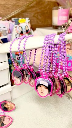 a bunch of necklaces with pictures hanging from them