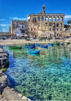 an image of boats in the water near a building with arches on it's roof