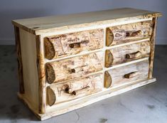 a wooden dresser sitting on top of a cement floor