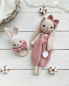 two stuffed animals sitting next to each other on a white wooden floor with lights in the background